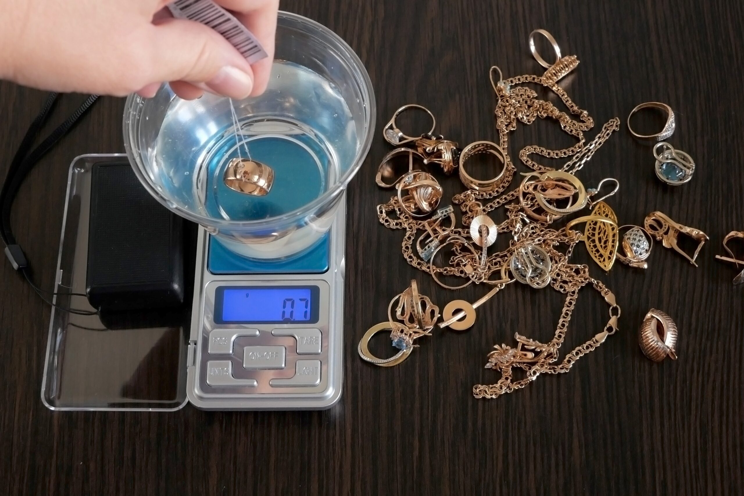 A jeweler is weighing different pieces of gold.