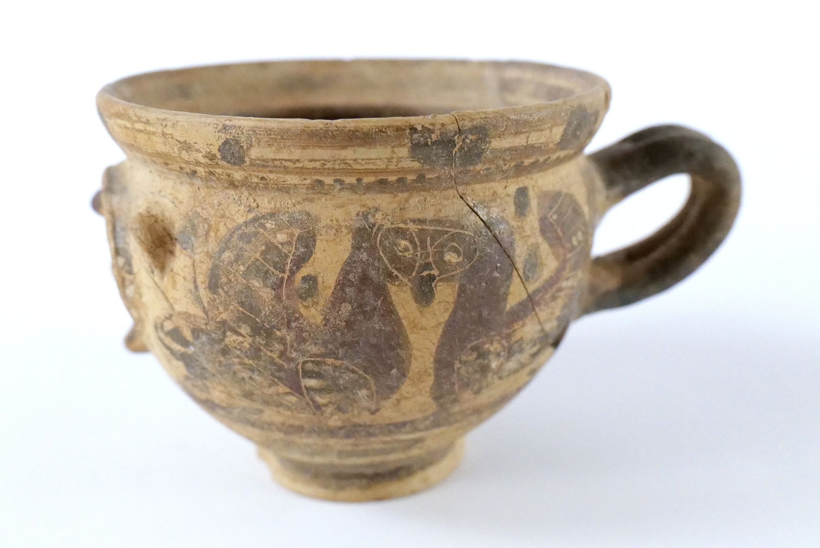 Greek Corinthian Black-Figured Face Pottery Cup. Circa 6th Century BCE. Possibly by the Otterlo Painter. Has been totally repaired with some missing pieces. Also has minor chip.